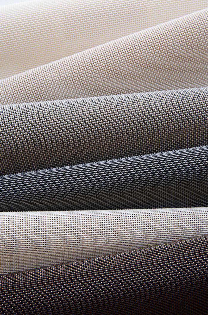 Stacked roller blind fabric swatches in neutral tones